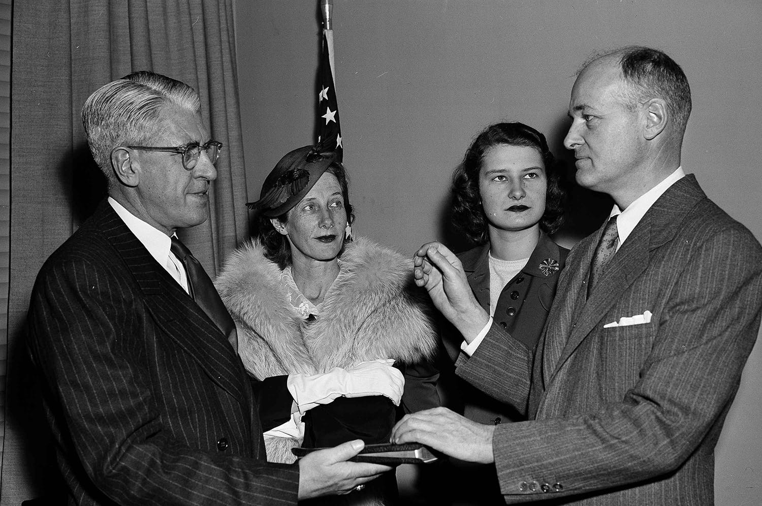 George F. Kennan becomes Ambassador to the Soviet Union in a State Department ceremony April 2, 1952. Kennan, left, reenacts the swearing in by Raymond Muir, protocol officer, with Mrs. Kennan (second from left), and daughter Grace, 19, looking on. (AP Photo/Byron Rollins)